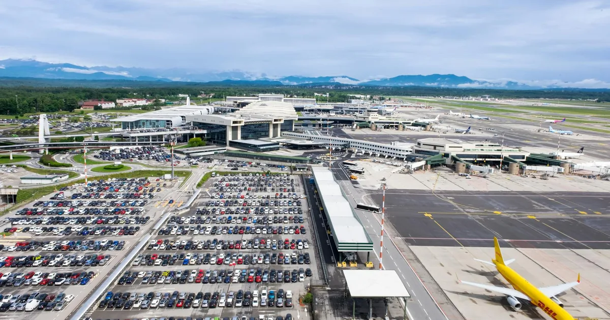 Aerial view of a busy airport parking lot with numerous parked cars.