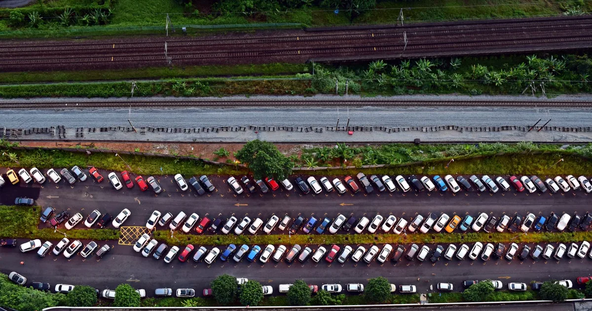 Aerial view of a busy parking lot with various parked cars and.