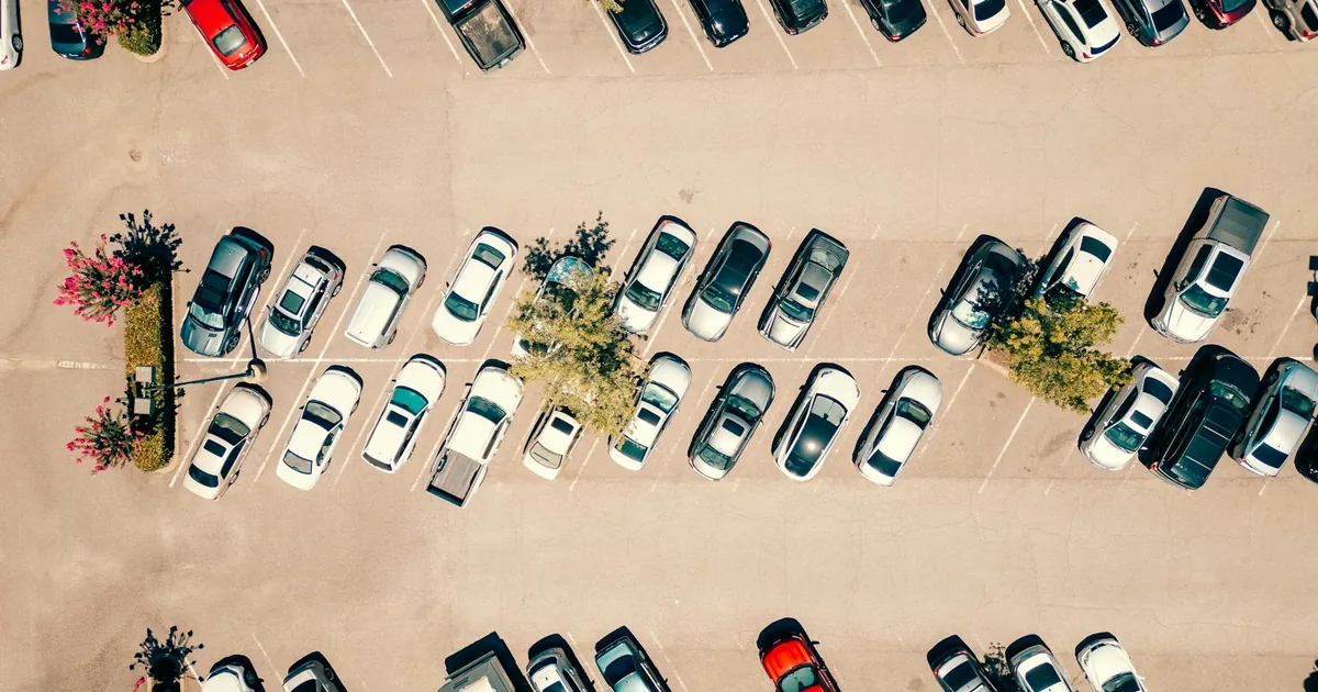 Aerial view of a busy parking lot with various parked vehicles and.