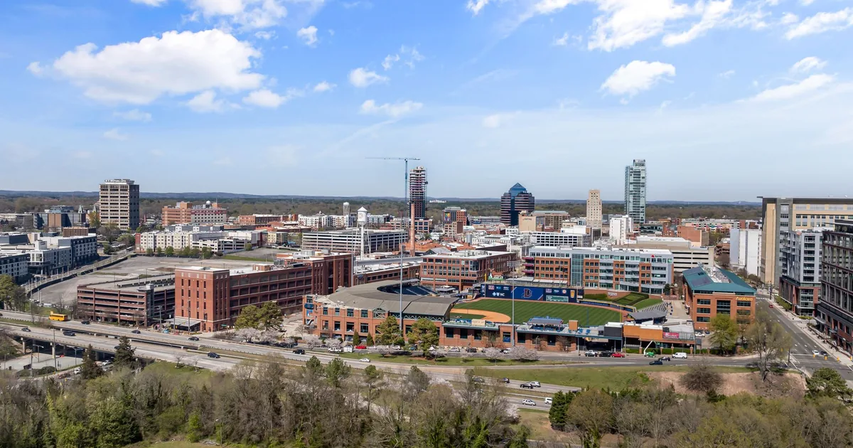 Aerial view of a busy urban parking area with buildings and roads.