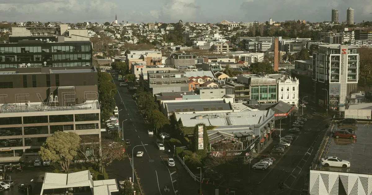 Aerial view of a city street with parked cars and buildings in the.