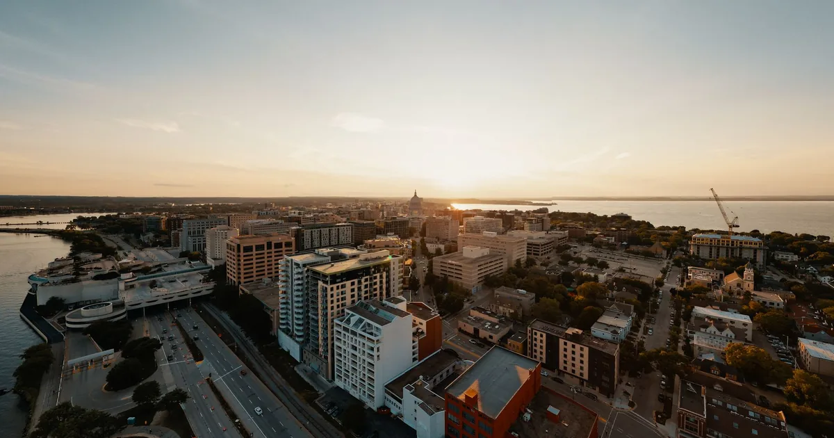 Aerial view of a cityscape with parked cars and sunset in the.