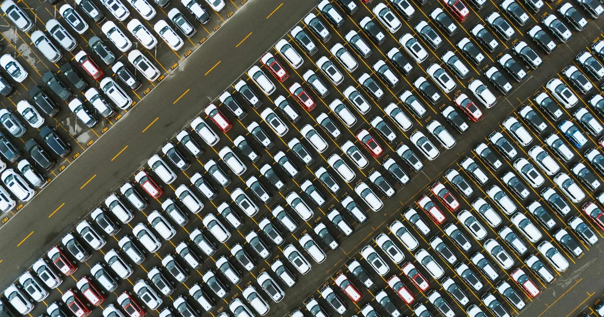 Aerial view of a crowded parking lot filled with various parked cars.