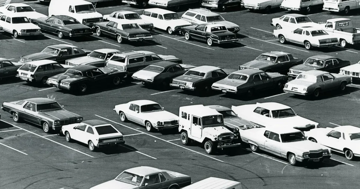 Aerial view of a crowded parking lot filled with various parked cars.