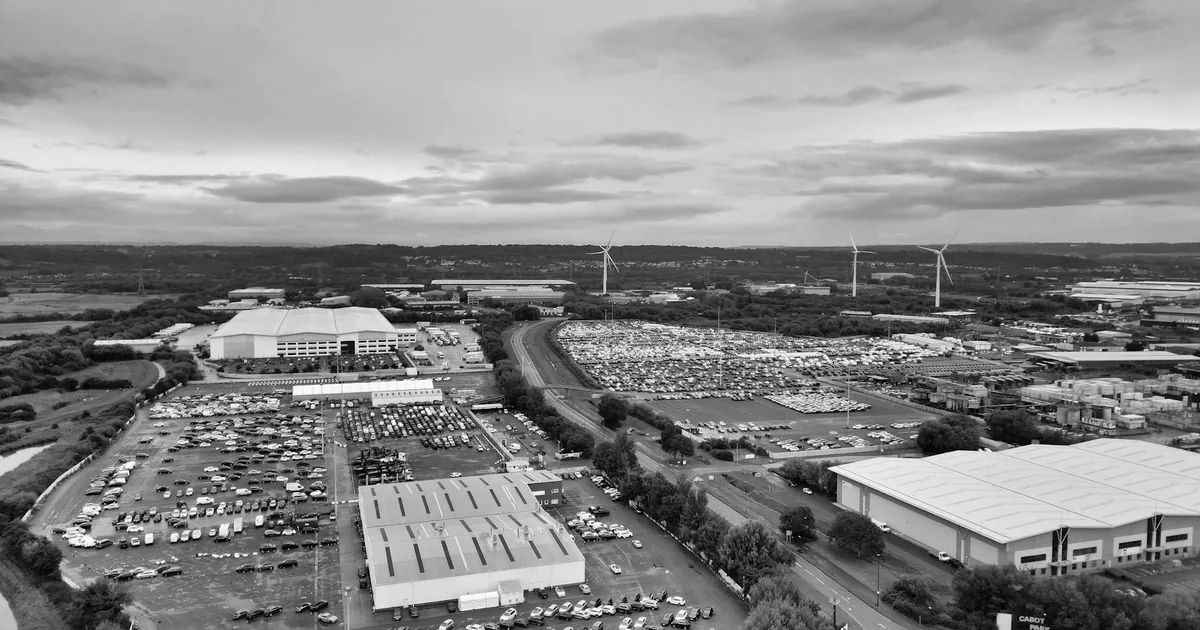 Aerial view of a large parking area with numerous vehicles and.