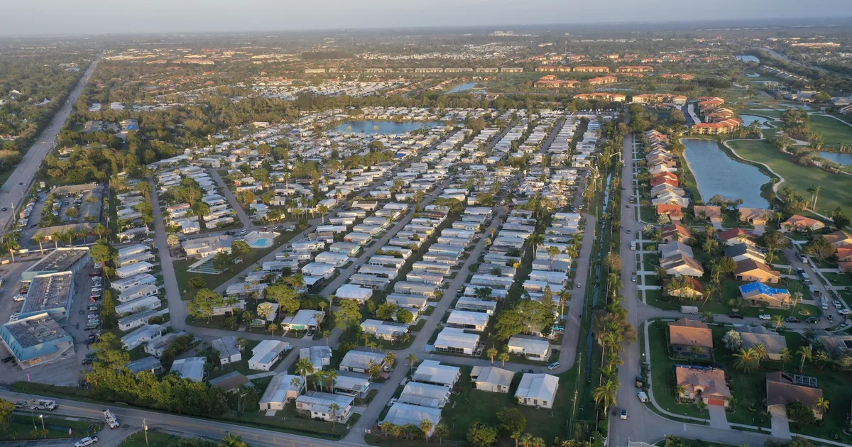 Aerial view of a large parking area with numerous vehicles and.