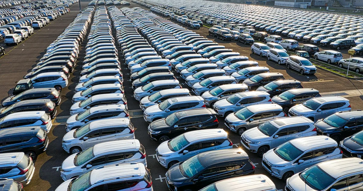 Aerial view of a large parking lot filled with rows of parked cars.