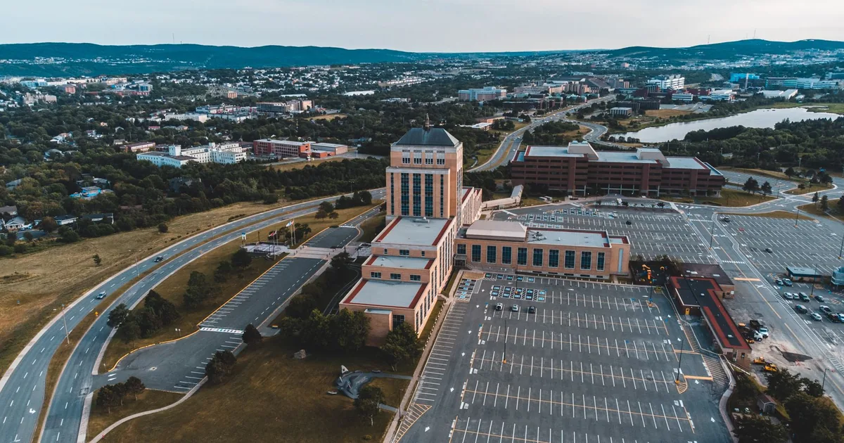 Aerial view of a large parking lot next to a multi story building.