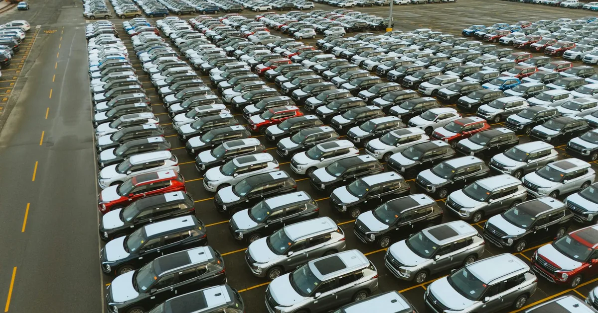 Aerial view of a large parking lot with rows of parked cars.