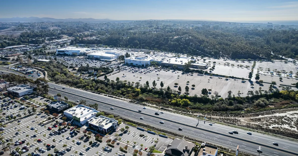 Aerial view of a large parking lot with vehicles and surrounding.
