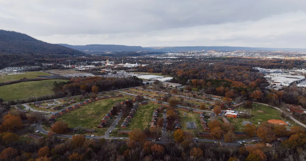 Aerial view of a parking area surrounded by trees and buildings in.