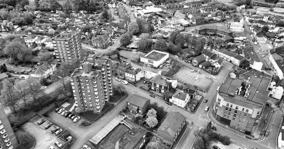 Aerial view of a parking lot surrounded by buildings and streets in.