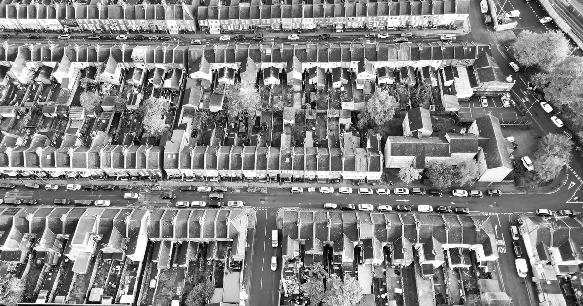 Aerial view of a residential area with parked cars along the street.