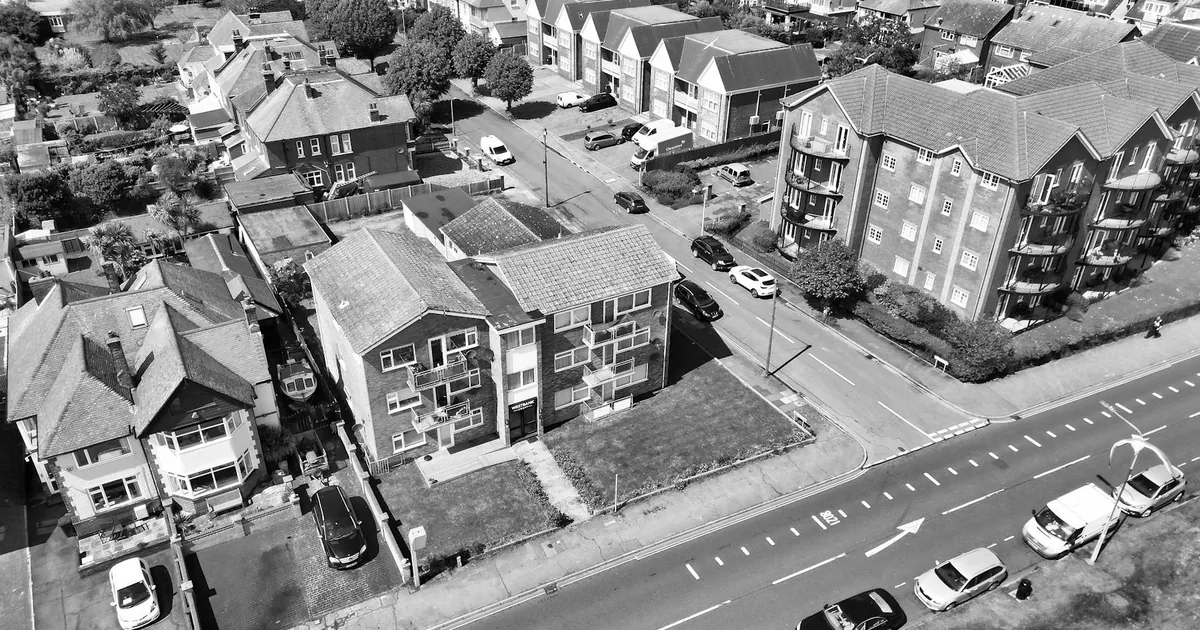 Aerial view of a residential area with parked cars and buildings.