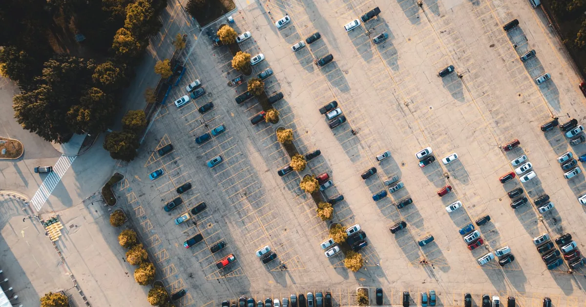 Aerial view of a spacious parking lot with various parked vehicles.
