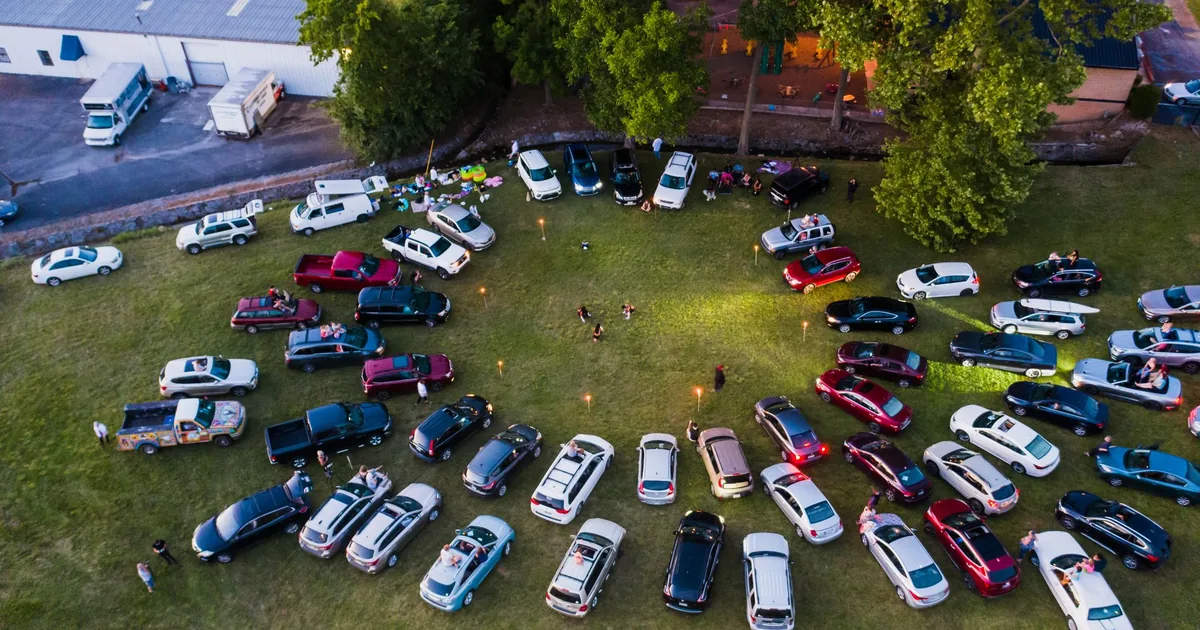 Aerial view of cars parked in a circular formation on grassy area.