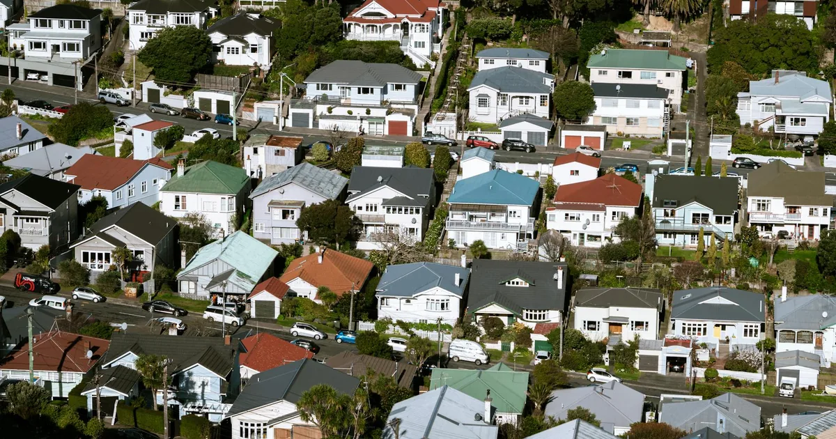 Aerial view of houses with parked cars in a residential neighborhood.