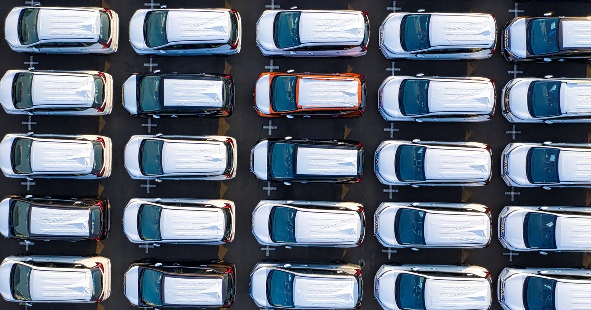Aerial view of multiple parked cars in a parking lot with white.