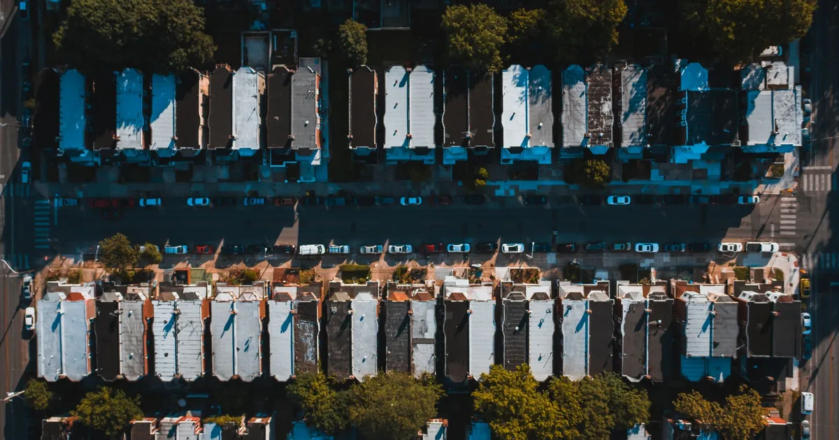 Aerial view of parked cars along residential streets with houses.