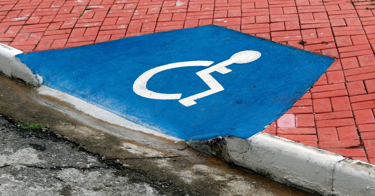 Blue painted accessible parking space on a red brick surface.