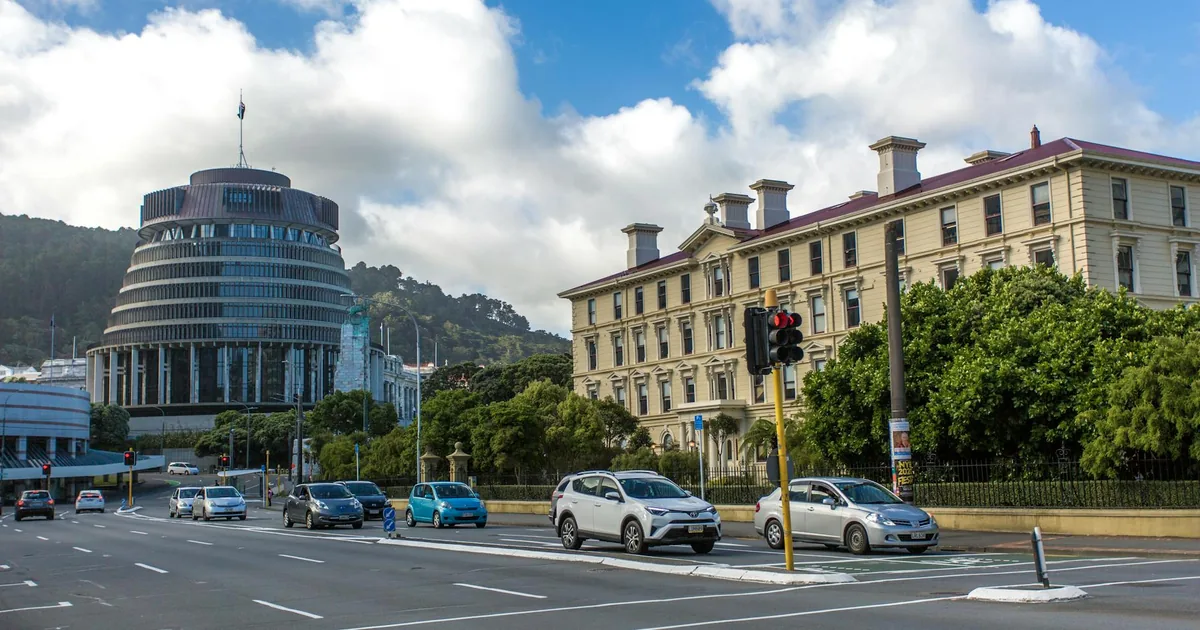 Cars parked along a street near modern and historic buildings under.