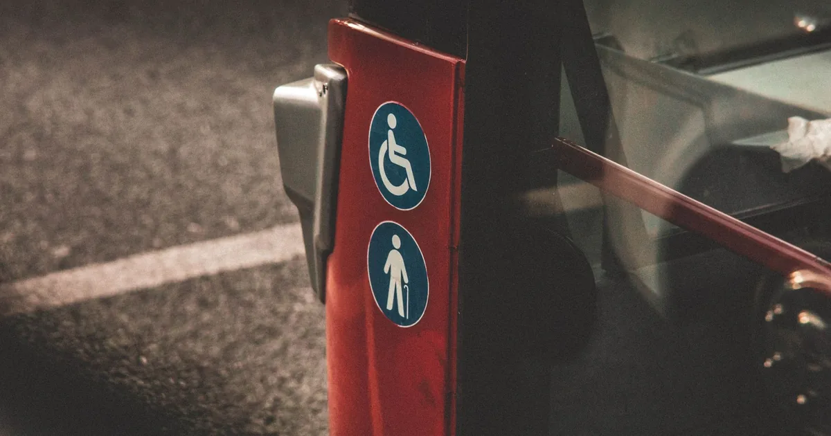 Close up of accessible parking signs on a vehicle in a parking lot.