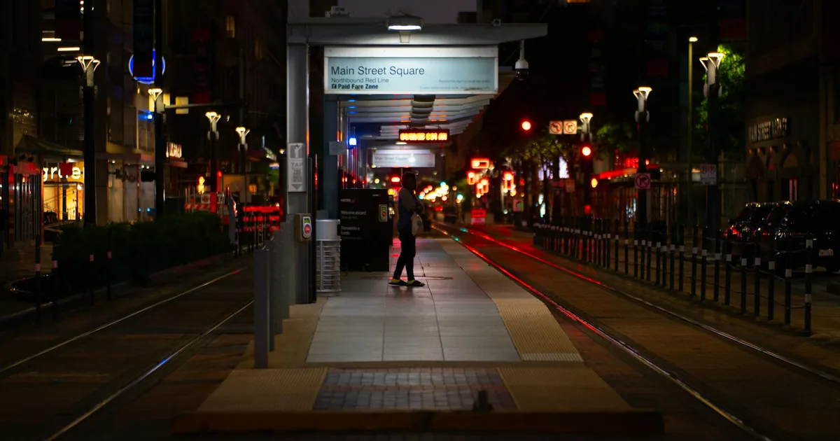 Dimly lit parking area with empty spaces and nearby street lights.
