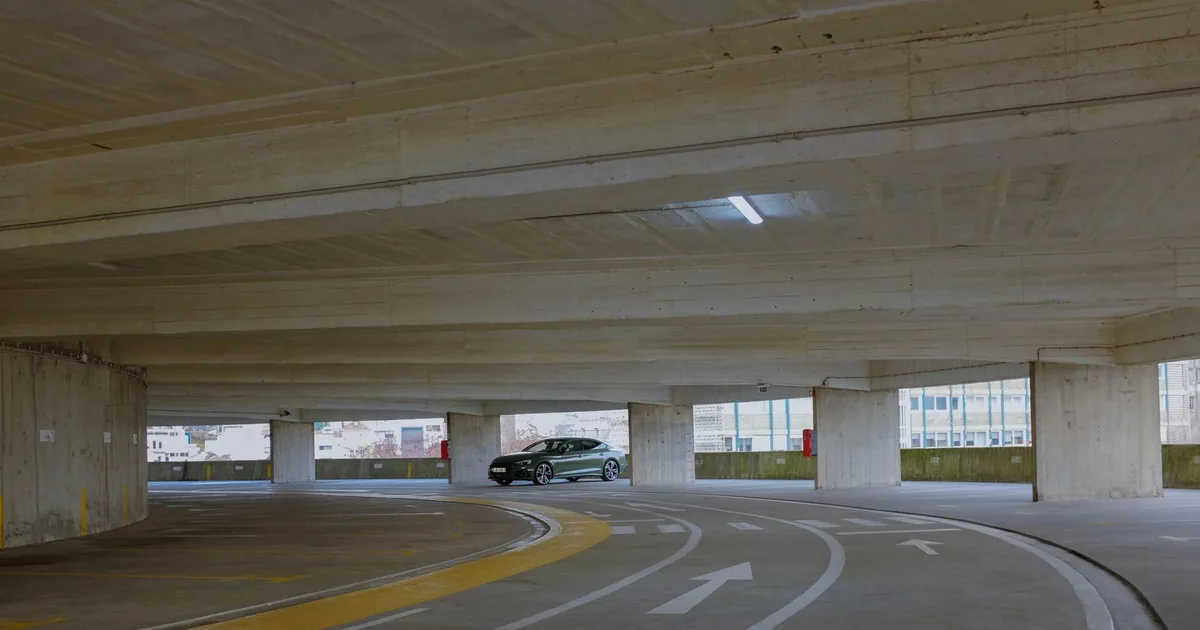 Interior of a parking garage with a car driving on a curved lane.