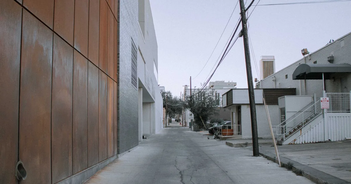 Narrow alley with buildings on both sides and parked vehicles in a.