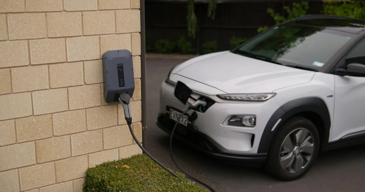 Parked electric vehicle connected to a charging station near a.
