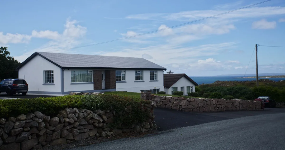 Parking area near a house with two cars and a scenic view in the.
