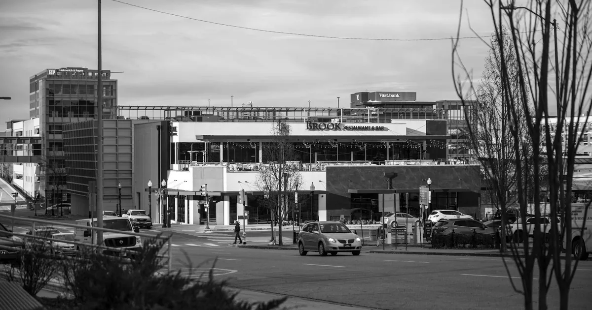 Parking area with cars near a commercial building and street.