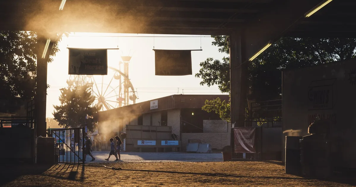 Parking area with people walking illuminated by sunset and dust in.