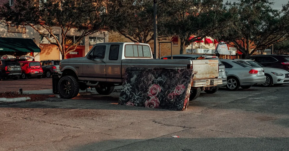 Parking lot scene featuring various vehicles and a decorative item.