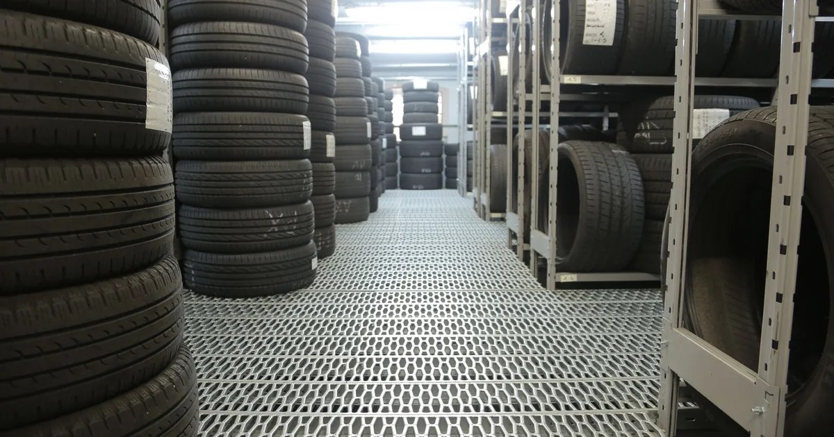 Parking space rental listing featuring stacked tires in a storage.