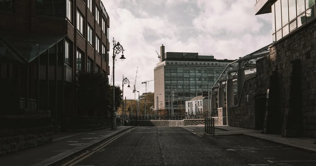 Quiet urban street with parking spaces and buildings on either side.