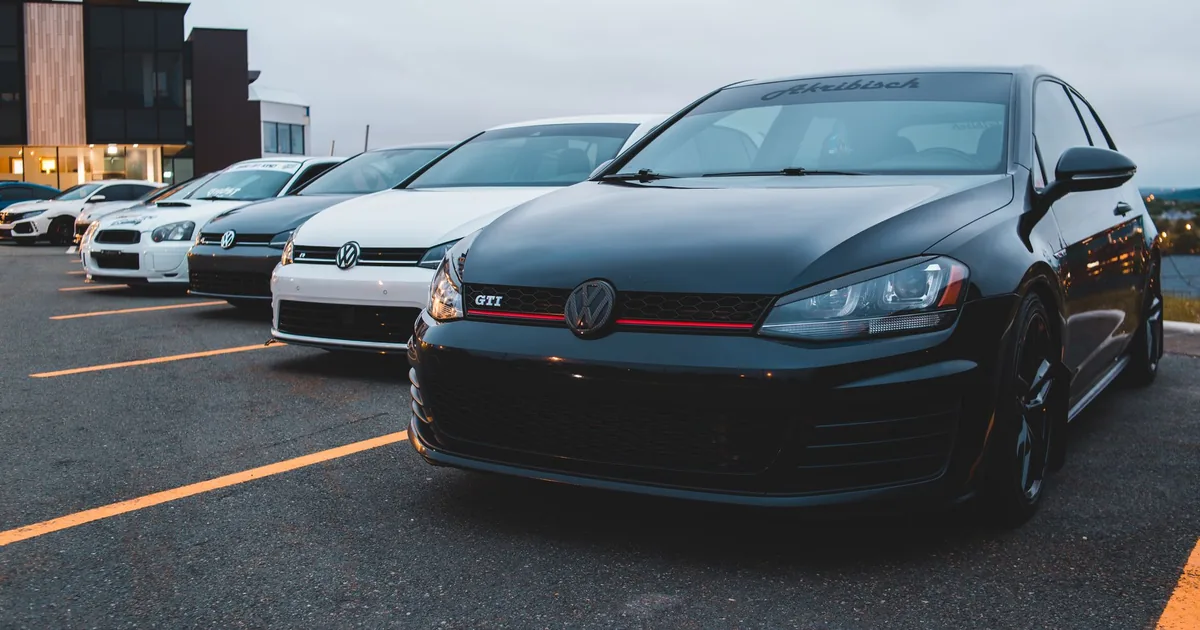 Row of parked cars in a parking lot with visible pavement markings.