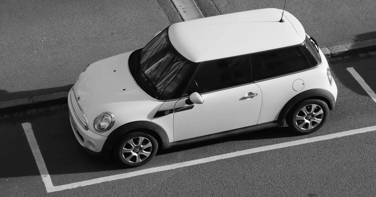 Small car parked in a designated parking space on a paved surface.