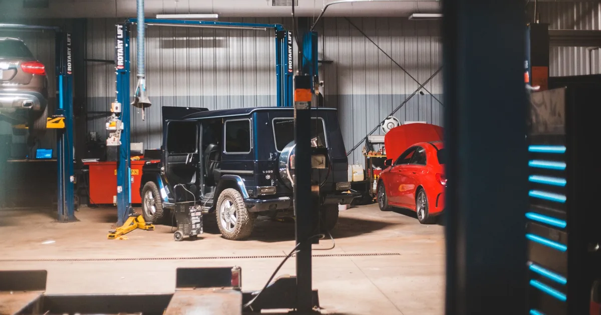 Spacious indoor parking area with two vehicles and service.