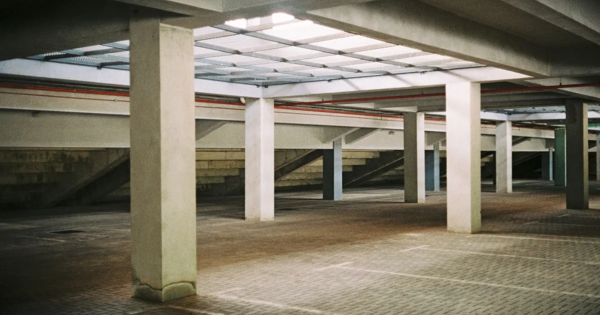 Spacious underground parking area with concrete pillars and empty.
