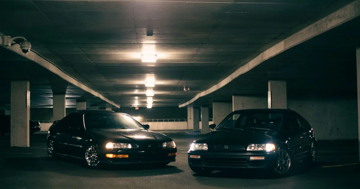 Two parked cars in a dimly lit underground parking garage.