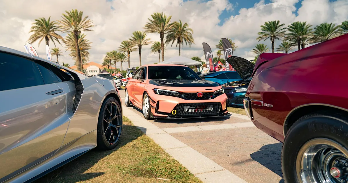 Vibrant parking area with various cars and palm trees under a sunny.