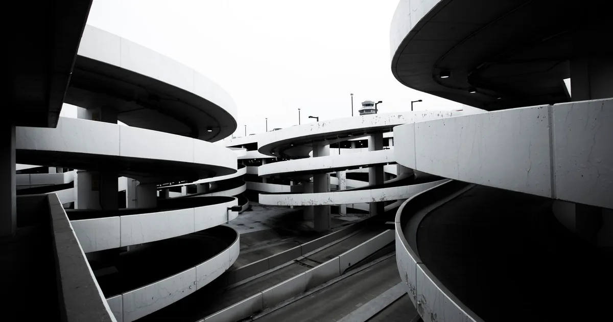 View of a multi level spiral parking garage with concrete ramps and.