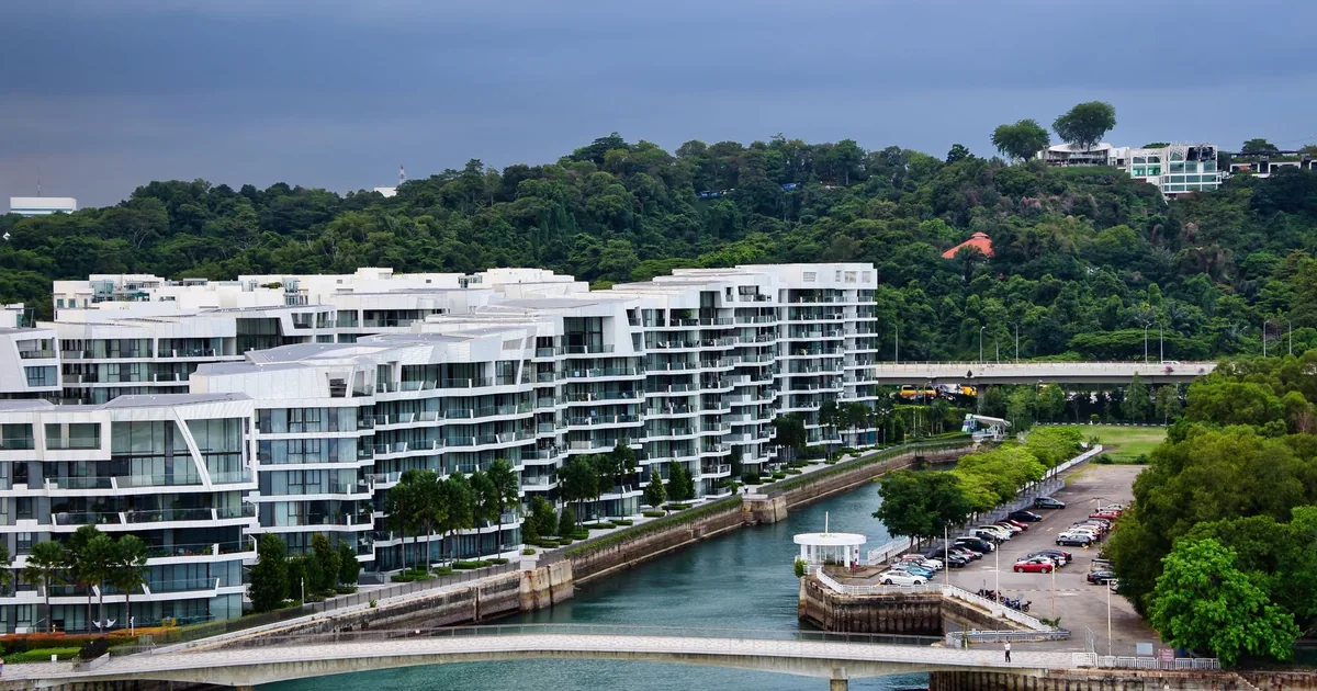 Waterfront parking area with several parked cars and modern.