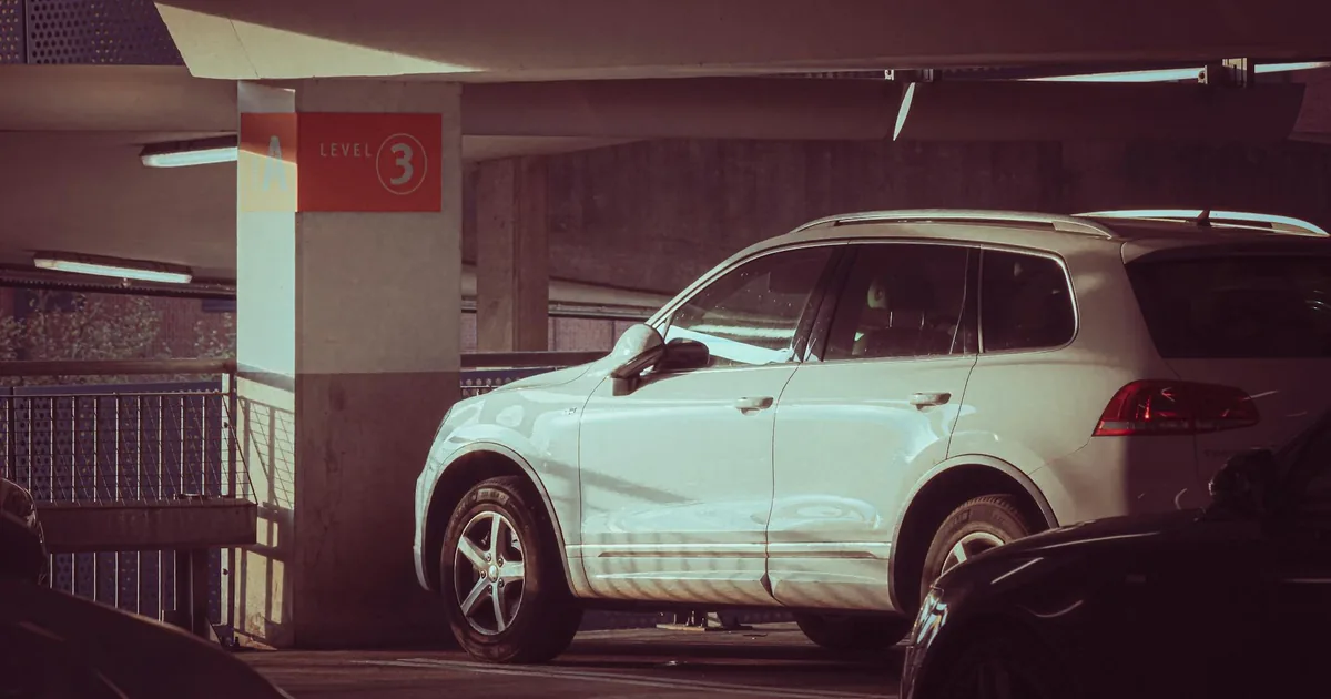 White vehicle parked on level 3 of a multi story parking garage.