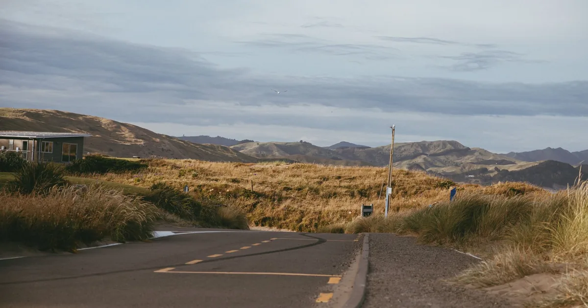 Winding road leading to a parking area surrounded by hills and.