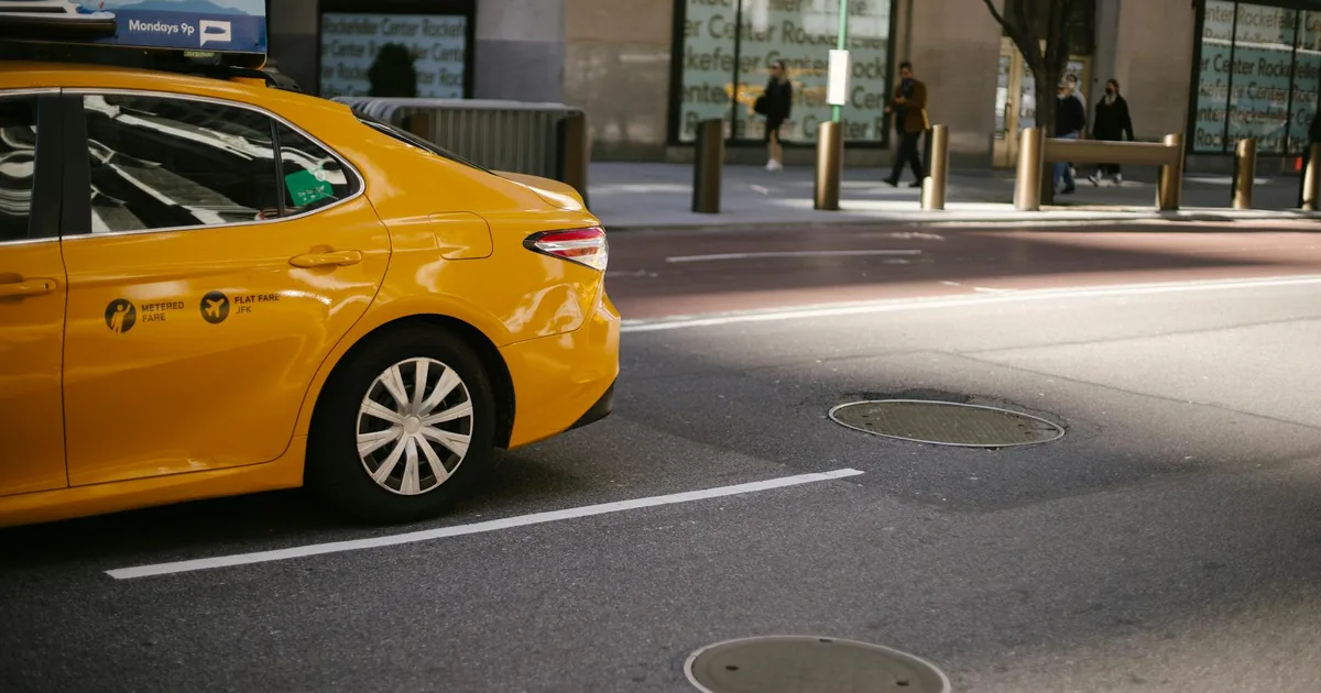 Yellow taxi parked in a designated space on a city street.