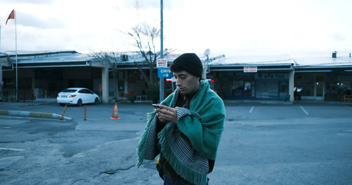 A man using a smartphone in a car park