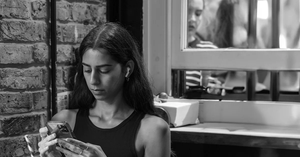 A young woman looking at her smartphone indoors